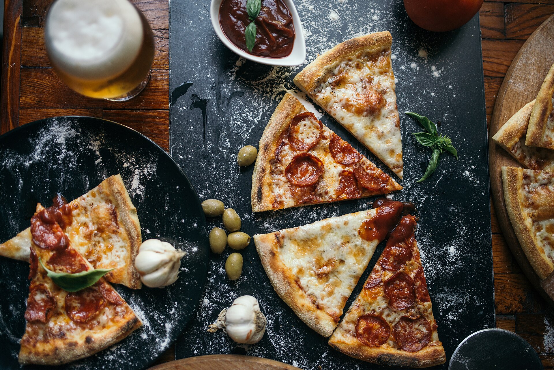 A wood-fired pizza on the table, blistered crust, melted cheese.